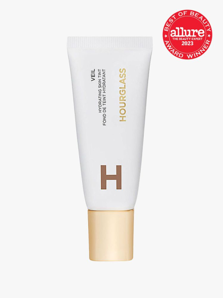 Hourglass Veil Hydrating Skin Tint white tube with gold cap on light gray background with red Allure Best of Beauty seal in the top right corner